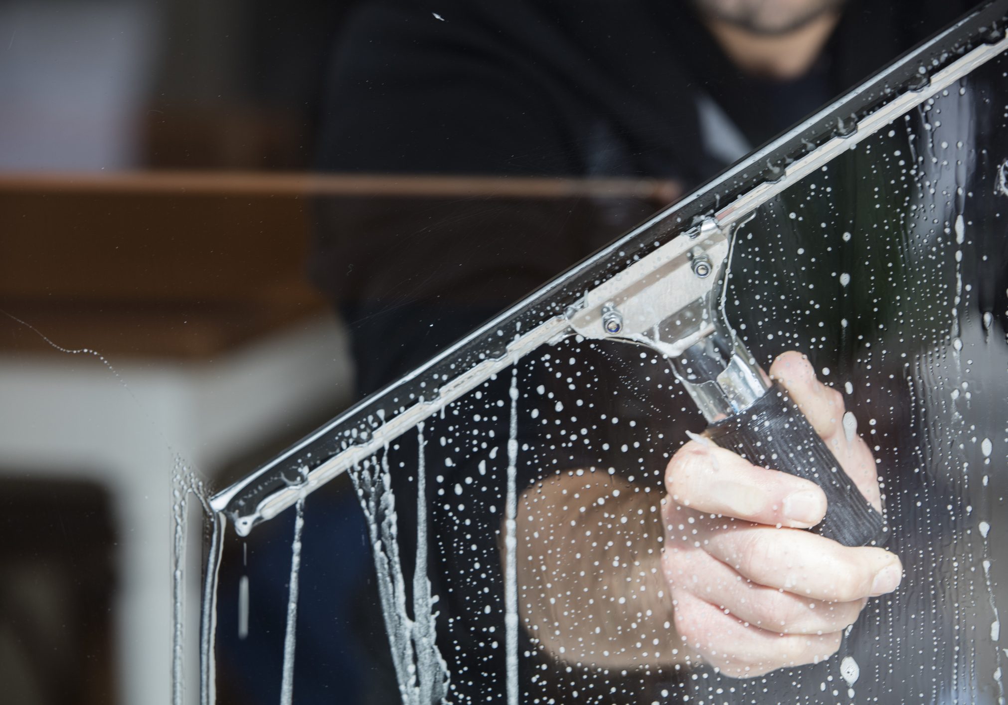 a soapy window with a squeegee cleaning the glass